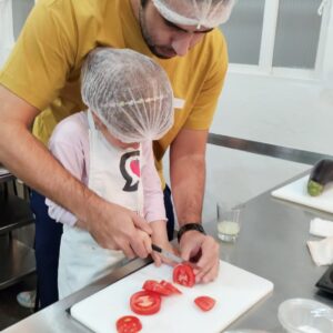 Férias de Julho<br>CRIANÇAS E ADULTOS<br>6 a 12 anos<br>Convide uma criança e venham cozinhar juntos<br>1 Aula